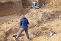 Archaeological excavations. The archaeologists in a digger process, researching the tomb with human bones, drawing the human remai