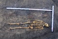 Archaeological excavations man and finds bones of a skeleton in a human burial; working tool; ruler; a detail of ancient researc