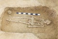 Archaeological excavations man and finds bones of a skeleton in a human burial, working tool, ruler, a detail of ancient resear