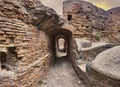 Archaeological excavations street view in Ostia Antica with ancient Roman ruin, vaults and pathways surrounded by brick walls