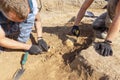 Archaeological excavations. Two archaeologists with tools conducting research on human bones on the ground tomb. Real process of d