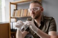 Archaeologist in the office. Scientist archaeologist looks at an artifact in packaging while sitting at his workplace
