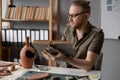 Archaeologist working in office reading ancient archaeological book