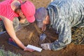 Archaeologists extract from the ancient tomb a piece of a bronze knife