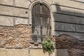 An arched barred window on the wall of an old house. Royalty Free Stock Photo