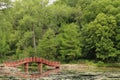 An arched bridge over a lake leading to walking trails thougha forest and around the lake in Wisconsin