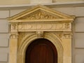 Arched stained wooden detail with ornate stone frame and tympanum