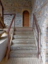 Arched door and wooden stairs of old stone building Royalty Free Stock Photo