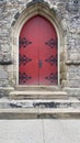 Old red wooden arched doorway with black accent metal Royalty Free Stock Photo