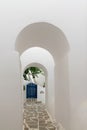 Arched doorways leading to a blue door. Traditional architecture of local villages at Paros island in Greece.