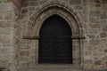 Arched Gate with Wooden Doors Wall of Stone Medieval Church Royalty Free Stock Photo