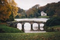 Arched historical bridge in Stourhead park, Stourton, England surrounded by beautiful autumn scene Royalty Free Stock Photo