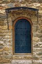 Arched medieval wooden door in a stone wall