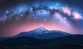 Arched Milky Way and mountains with snow covered peak at night Royalty Free Stock Photo