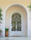 An arched portico house entrance with a classic design iron cast door and potted flowers Royalty Free Stock Photo