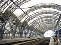 The arched roof of the railway station as an iron and glass structure over the railway tracks in perspective Royalty Free Stock Photo