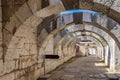 Arched stone passage in ancient ruins with sunlit path. Authentic ancient Smyrna ruins in Izmir, Turkey Royalty Free Stock Photo