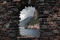 Arched stone window or opening in a stone wall overlooking scenic landscape of ligurian sea and mountains in Portovenere, Italy Royalty Free Stock Photo