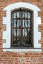 Arched window with bars in the red brick wall. An old building with beautiful Windows and white arches. An old fortress or castle Royalty Free Stock Photo