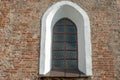 Arched window with bars in the red brick wall. An old building with beautiful Windows and white arches. An old fortress or castle Royalty Free Stock Photo