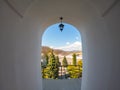 Arched window with view to autumnal alpine landscape, bright sunshine