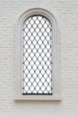 Arched Window With Wrought Iron Lattice And Decorative Figures In The Brick Wall. Window Isolated With Clipping Path