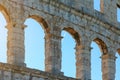 Arched windows of an ancient Roman amphitheater against the blue sky Royalty Free Stock Photo