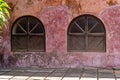 Arched windows of an old building with a rustic red wall, taken on Prison Island Zanzibar Tanzania Royalty Free Stock Photo