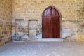 Arched wooden door and two embedded niches in stone bricks wall, Old Cairo, Egypt Royalty Free Stock Photo