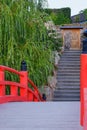 Arched wooden red footbridge and stone steps of stairway leading up to the temple gate Royalty Free Stock Photo