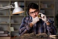 The archeologist working late night in office Royalty Free Stock Photo