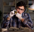 Archeologist working late night in office Royalty Free Stock Photo
