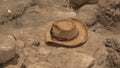 An Archeologists hat rests on an excavation dig site