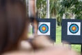 Archer aiming at twin archery targets on an outdoor range surrounded by tropical palm trees, emphasizing focus and depth of field Royalty Free Stock Photo