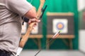 Archer hands close up, preparing the arrow for the shot.