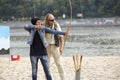 An archer teaching young woman archery on the sandy beach of the river, arrows, quiver and bow