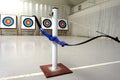 Archery bow hanging on its stand, with targets in background Royalty Free Stock Photo
