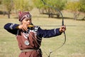 Almaty / Kazakhstan - 09.23.2020 : A teenager in national dress learns to shoot a bow