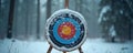 Archery target sits covered in snow within a winter forest landscape. It features colorful rings ready for shooting practice or Royalty Free Stock Photo