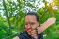 archery, young woman with an arrow in a bow focused on hitting a target Royalty Free Stock Photo