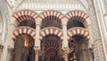 Arches of the ancient and impressive Mosque Cathedral of Cordoba from inside.