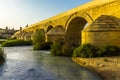 The arches and buttresses of the Roman bridge of Cordoba, Spain illuminated by the evening sun Royalty Free Stock Photo