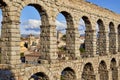 Arch detail of the Aqueduct of Segovia, with the tower bell of the Saint Justo y Pastor church in the background. View from