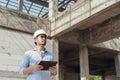 Architect Asian man wearing safety helmet and holding digital tablet for work at construction site Royalty Free Stock Photo