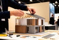 Architect assembling modern house model in exhibition hall Royalty Free Stock Photo
