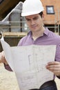 Architect On Building Site Looking At House Plans Royalty Free Stock Photo