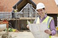 Architect On Building Site Looking At House Plans Royalty Free Stock Photo