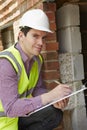 Architect Checking Insulation During House Construction Royalty Free Stock Photo