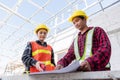 Architect and client discussing help create plan with blueprint of the building at construction site Royalty Free Stock Photo