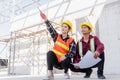 Architect and client discussing help create plan with blueprint of the building at construction site Royalty Free Stock Photo